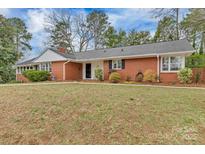 Charming red brick home featuring a well-maintained lawn and colorful landscaping at 1101 Roundknob Ave, Salisbury, NC 28144