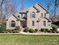 Charming two-story brick home with a well-manicured lawn and mature landscaping at 11243 Home Place Ln, Mint Hill, NC 28227
