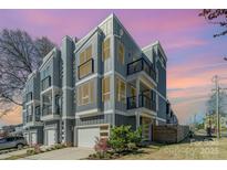 Modern townhome exterior with gray siding, balconies, and attached garages under a vibrant sky at 1659 Duckworth Ave, Charlotte, NC 28208