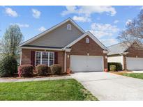 Charming brick home with a well-manicured lawn and a two-car garage and beautiful landscaping at 1668 Onyx Rdg # 116, Fort Mill, SC 29708