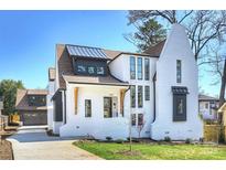 Stunning exterior of a brick home featuring modern design elements and manicured landscaping under a clear blue sky at 2325 Winthrop Ave, Charlotte, NC 28203