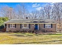 Charming brick home with well-maintained lawn, blue front door and dark shutters for a traditional feel at 2913 Archdale Dr, Charlotte, NC 28210