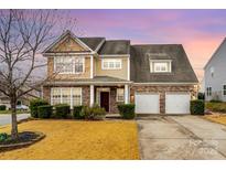 Charming two-story home with stone accents, attached two car garage, and manicured lawn at 3301 Brackhill St, Davidson, NC 28036
