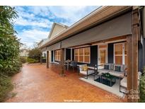 Inviting patio space featuring patterned flooring, stylish seating, and retractable awnings for comfortable outdoor living at 3301 Brackhill St, Davidson, NC 28036