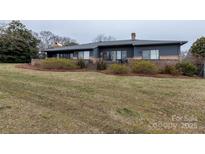 Expansive backyard featuring a brick retaining wall and lush green lawn at 404 Downing Dr, Kings Mountain, NC 28086
