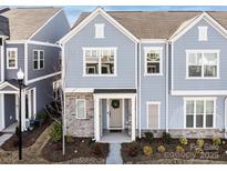 Charming two-story townhome with stone accents, light blue siding, and a welcoming front door with wreath at 527 Morrows Turnout Way, Pineville, NC 28134