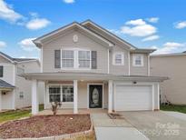 Charming two-story home featuring a covered front porch and attached one car garage at 10312 Hugue Way, Charlotte, NC 28214