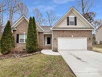 Charming brick home featuring a two-car garage, and lovely, mature landscaping at 12332 Flatbush Dr, Huntersville, NC 28078