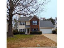 Charming two-story home featuring a brick facade, two-car garage, and a well-manicured front lawn at 12421 Poplar Forest Dr, Charlotte, NC 28278
