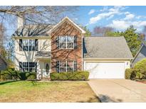 Charming two-story home features a blend of siding and brick, complemented by a well-maintained lawn and mature landscaping at 12421 Poplar Forest Dr, Charlotte, NC 28278