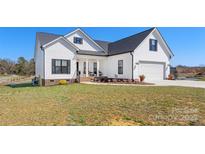 Charming two-story home with white siding, black shutters and a well-manicured lawn at 1323 Stack Rd, Monroe, NC 28112