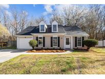 Charming one-story home with a manicured lawn, dormer windows, and attached garage at 13701 Dawlish Ln, Pineville, NC 28134