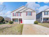 Charming two-story home with red shutters, front yard, and driveway on a sunny day at 203 Waterlemon Way, Monroe, NC 28110