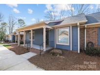 Inviting townhome exterior showcasing a covered front porch, brick foundation, and well-maintained landscaping at 234 Pointe Cir, Rock Hill, SC 29732
