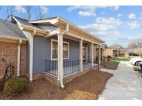 Charming townhome displaying a covered front porch and brick foundation with impeccable curb appeal at 234 Pointe Cir, Rock Hill, SC 29732