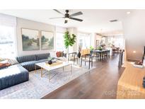 Bright open-concept living room features modern decor, stylish furniture, and seamless flow to the kitchen and dining area at 305 Old Town Village Rd, Waxhaw, NC 28173