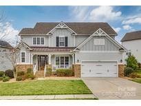 Charming two-story home featuring a well-manicured lawn, stone accents and a two car garage at 5431 Meadowcroft Way, Fort Mill, SC 29708
