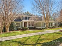 Charming two-story home featuring a covered porch, landscaped yard, and well-maintained lawn on a sunny day at 8416 Highgrove St, Charlotte, NC 28277