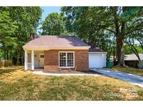 Charming single-Gathering brick home with a well-manicured lawn and an attached garage at 8515 Mission Hills Rd, Charlotte, NC 28227