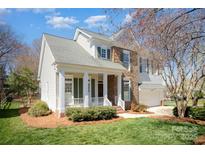 Charming two-story home with a stone facade, a well-manicured lawn and a cozy front porch at 10502 Orchid Hill Ln, Charlotte, NC 28277