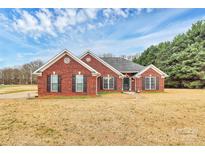 Charming single-story brick home featuring classic shutters and a well-manicured front lawn at 13930 Thompson Rd, Mint Hill, NC 28227