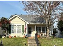 Charming home with light-yellow siding, green shutters, and inviting front porch with seasonal decor at 1505 Andora Dr, Rock Hill, SC 29732