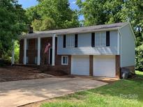 Charming two-story home boasts a two-car garage and a covered front porch, creating a welcoming curb appeal at 1608 Van Dyke Dr, Charlotte, NC 28213