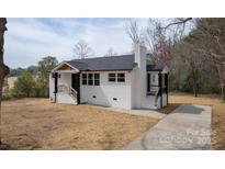 Charming, recently renovated one-story home featuring a classic white brick facade and dark trim at 244 Stilwell Oaks Cir, Charlotte, NC 28212