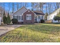 Charming home featuring brick accents, green shutters, and a well-maintained front lawn at 306 Chinaberry Dr, China Grove, NC 28023