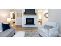 Inviting living room features a white brick fireplace, wood floors, and neutral decor at 3520 Colony Rd # E, Charlotte, NC 28211