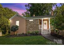 Charming single-story home with stone accents, manicured lawn, and inviting front porch at 4010 Hiddenbrook Dr, Charlotte, NC 28205