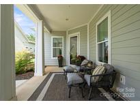 Inviting covered porch with stylish seating and outdoor rug for a relaxing welcome at 4922 Looking Glass Trl, Denver, NC 28037