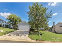 Charming home with a two-car garage, lush lawn, and a mature shade tree enhancing curb appeal at 7121 Lanark Ct, Charlotte, NC 28217