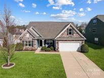 Charming home with stone accents, well-manicured lawn and a two-car garage on a sunny day at 7348 Adirondack Dr, Denver, NC 28037