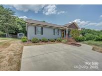 Charming single-story home with gray siding, black shutters, landscaped front yard, and a spacious concrete driveway at 102 Lee St, Belmont, NC 28012