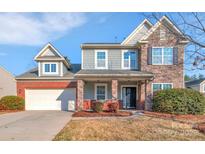 Charming two-story home with a mix of brick and stone accents and a well-manicured front yard at 12724 Hunting Birds Ln, Charlotte, NC 28278