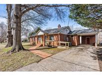 Charming brick home featuring a covered porch, convenient carport, and inviting brick walkway at 1407 17Th Ne Ave, Hickory, NC 28601