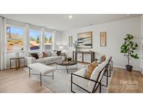 Bright living room with light wood floors, large windows, and elegant decor at 15140 Caspian Way, Charlotte, NC 28278