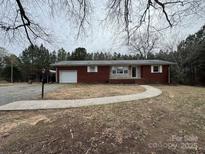 Charming single-story brick home with a walkway leading to the front door and a detached garage at 1575 Simplicity Rd, Concord, NC 28025