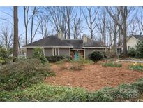 Charming single-story home features a well-manicured front yard and a striking blue front door at 1715 Shagbark Ln, Charlotte, NC 28226