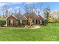 Charming brick home with lush green lawn, inviting curb appeal, and mature landscaping at 2019 W Laporte Dr, Charlotte, NC 28216