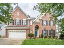 Charming two-story brick home with black shutters, arched entry and two-car garage on a manicured lawn at 21514 Gulfstar Ct, Cornelius, NC 28031