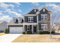 Charming two-story home with gray siding, white trim, and well-manicured landscaping at 3002 Paddington Dr, Indian Trail, NC 28079