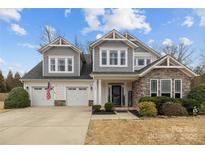 Charming two-story home boasts a two-car garage, stone accents and manicured landscaping at 3549 Sandy E Trl, Fort Mill, SC 29707