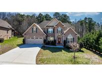 Stately brick home featuring a well-manicured front yard, arched windows and a three car garage at 3815 10Th Ne St, Hickory, NC 28601