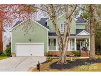 Charming two-story home with light green siding, white garage door, and inviting front porch at 433 Runnymede Dr, Rock Hill, SC 29732
