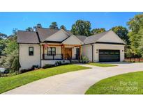 Inviting white brick home featuring a 2-car garage, covered porch, and well-maintained landscaping at 4808 1St Nw St, Hickory, NC 28601