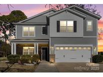Charming two-story home with a well-manicured lawn and a two-car garage at 5703 Eleanor Rigby Rd, Charlotte, NC 28278