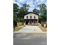 Charming brick two-story home with a long concrete driveway and fenced yard at 588 Washington Ln, Albemarle, NC 28001