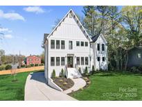 Stunning two-story white home with modern black-framed windows and a beautifully landscaped front yard at 621 Poindexter Dr, Charlotte, NC 28209